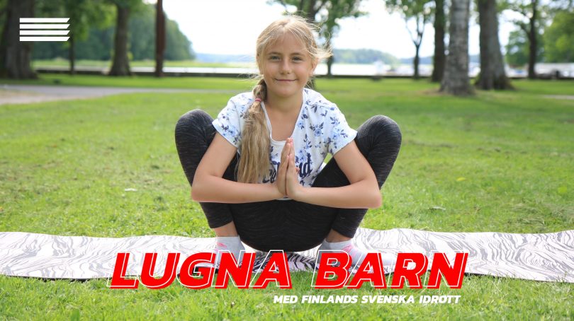 Grodan görs av en flicka på en grön gräsmatta.