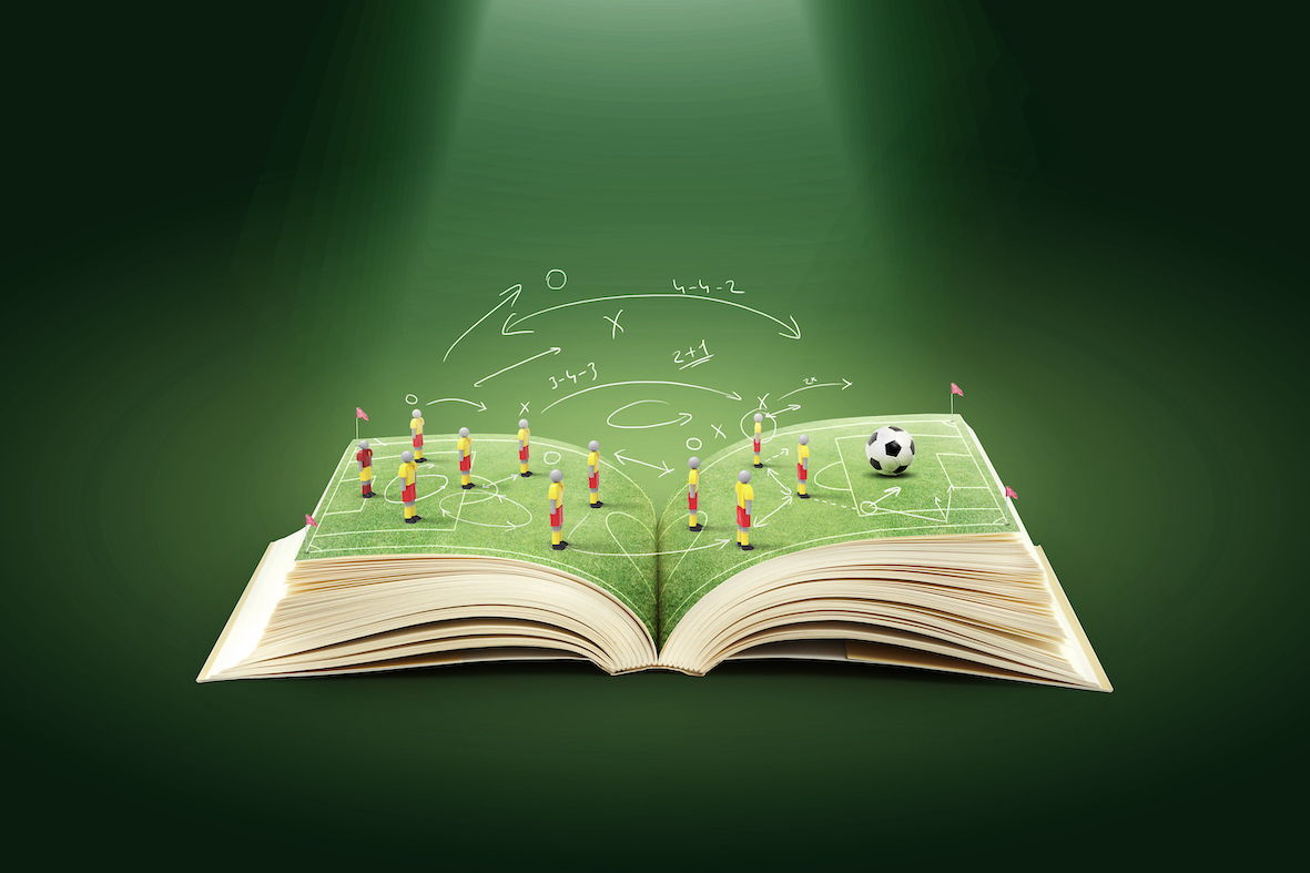 En öppnad bok med en fotbollsplan på mittuppslaget