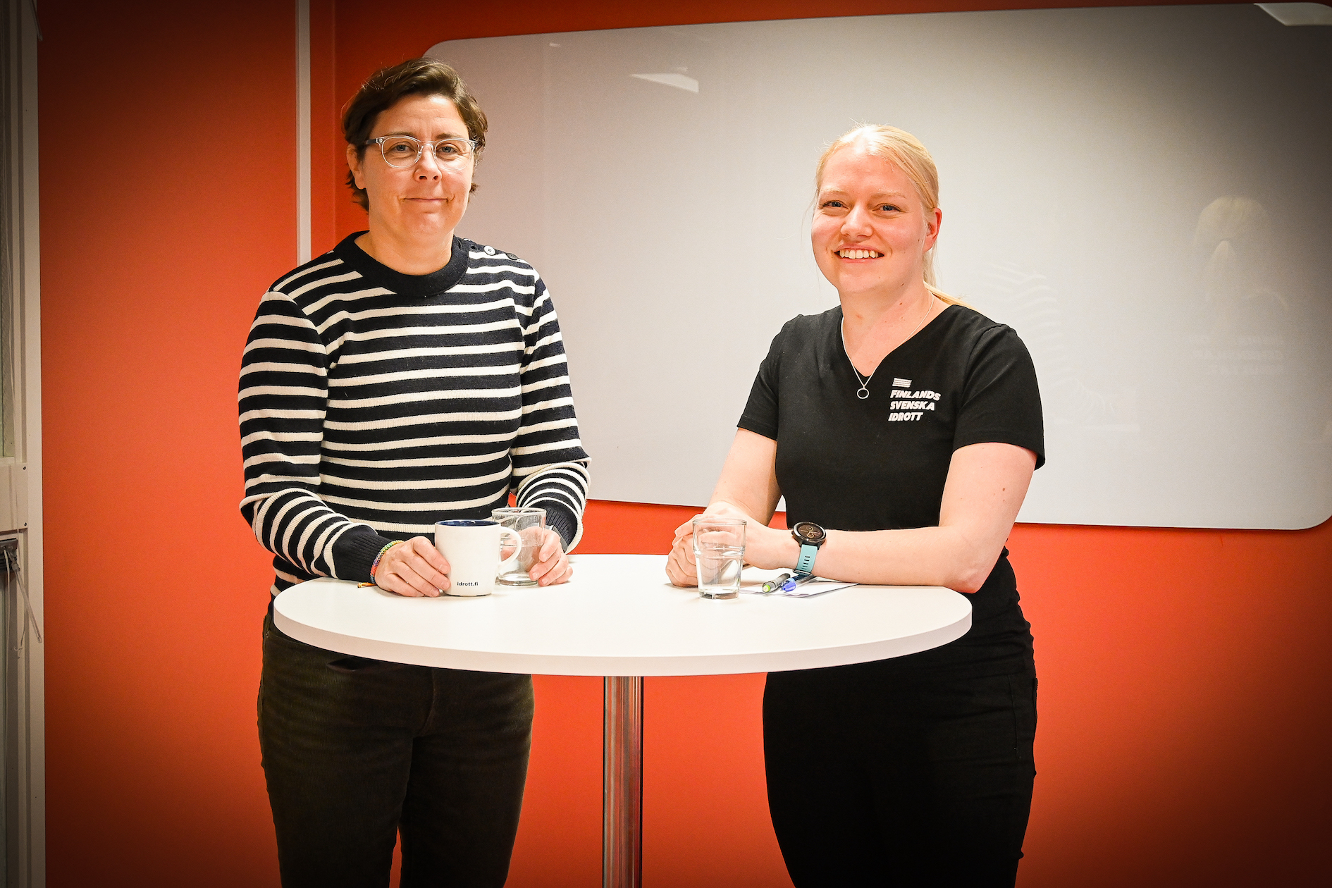 Tarja Krum och Birgitta Lindholm står bredvid varandra vid ett vitt bord.