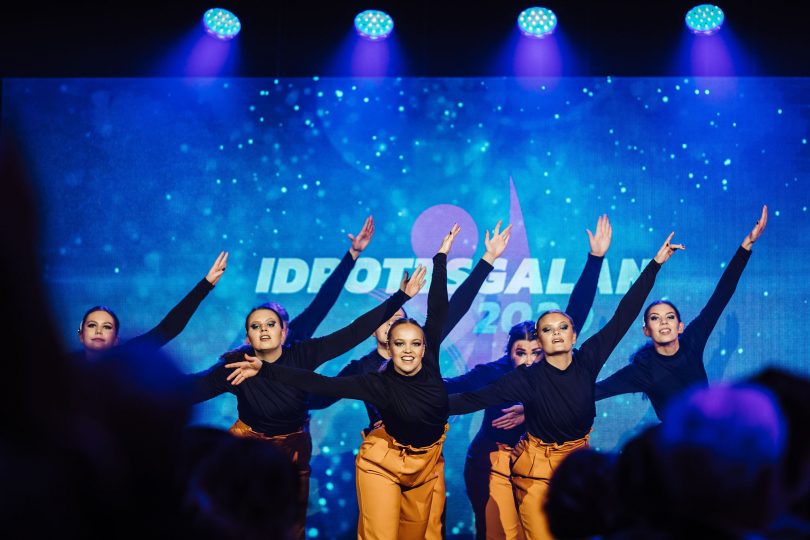 En grupp dansare på en scen som dansar. I bakgrund ser man rubriken idrottsgalan 2021.