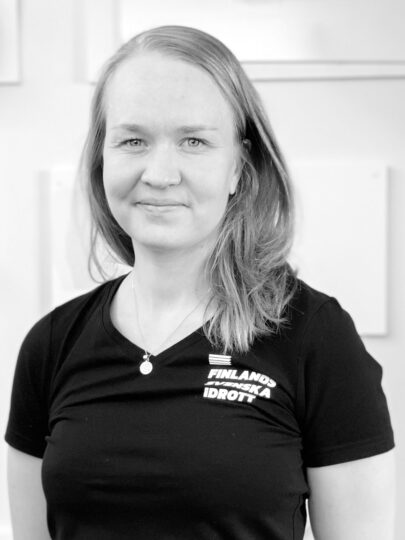 En svartvit bild på Jonna Skrifvars när hon poserar med armarna bakom ryggen.